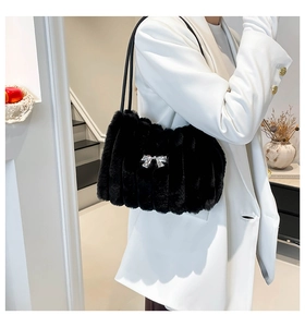 Détail du sac bandoulière en fausse fourrure noire avec rayures et nœud argenté sur blazer