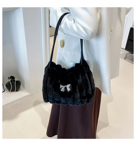 Détail du sac bandoulière en fausse fourrure noire avec nœud en métal argenté et lanière