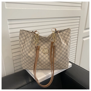 Close-up of beige tote bag with M-pattern print, gold logo, and chain shoulder strap