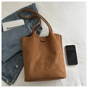 Close-up of a caramel faux suede tote bag with textured shoulder straps and minimalist style