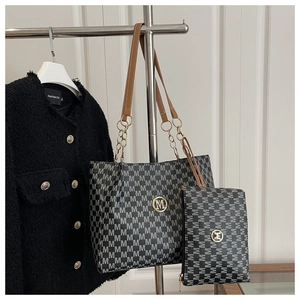 Detail of gray monogram tote bag with gold M logo, matching pouch and chain strap