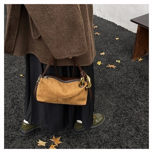 Detail view of retro patchwork handbag with gold metal ring buckle and suede texture