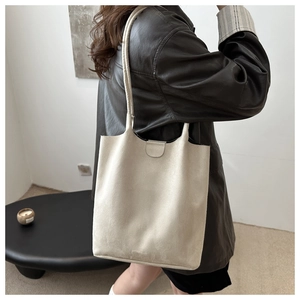 Detail view of large beige tote bag featuring a practical magnetic snap closure design