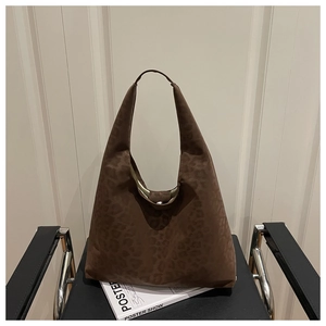 Detail of a large brown leopard print hobo bag with suede texture and metal buckle clasp