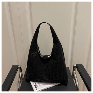 Detail of black leopard print suede hobo bag textured fabric on a stylish chair