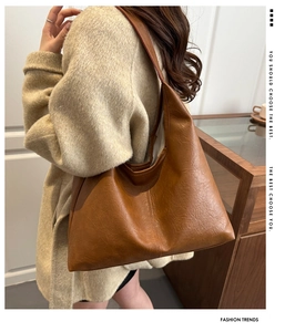 Gros plan du sac porté épaule en cuir marron sur mannequin avec manteau en laine beige