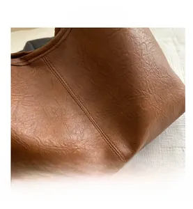 Gros plan d'un sac en cuir marron montrant les coutures et la texture du matériau