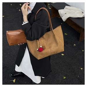 Detail of suede tote bag with red pompom charm and matching zipper pouch for women