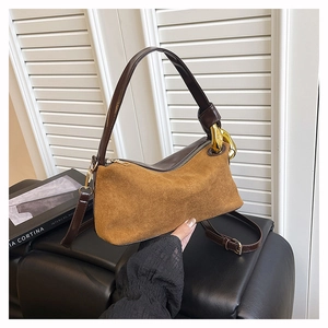 Detail of vintage suede shoulder bag with gold chain accents and brown leather trim