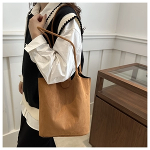Brown suede tote bag shown on shoulder for daily commute with a large capacity