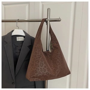 Close-up of leopard print tote bag showing soft matte texture and spacious shoulder strap