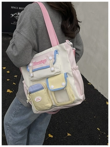 Detail view of multi-pocket patchwork tote bag in pastel colors with buckle details