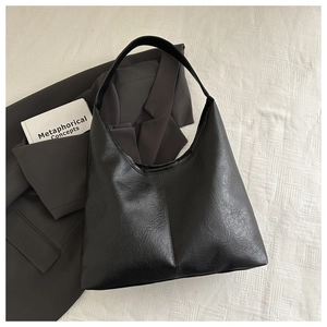 Détail du grand sac cabas vintage en cuir noir avec texture souple pour les déplacements
