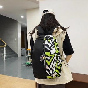 Graffiti print backpack with astronaut charm and modern asymmetrical black and green design