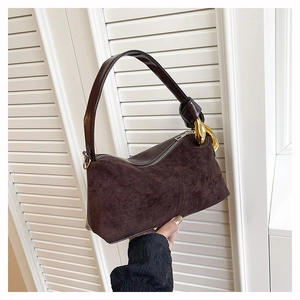 Detail of dark brown vintage handbag featuring mixed textures and gold hardware accents