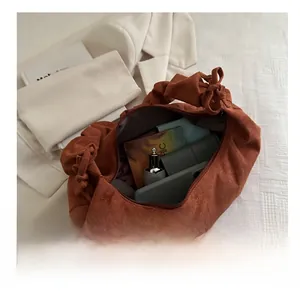 Vue intérieure montrant la grande capacité du sac en daim marron avec les essentiels
