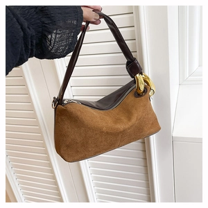 Detail of two-tone vintage shoulder bag with brown suede texture and gold chain link