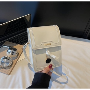 Gros plan d'un mini sac à bandoulière blanc avec texte FASHION doré et pendentif en métal