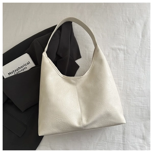 Détail du sac hobo en cuir blanc crème avec texture plissée naturelle et large bandoulière