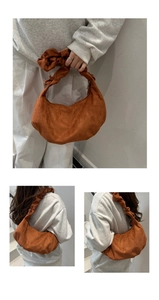 Détail de la bandoulière plissée et texture suède de ce sac hobo moderne marron