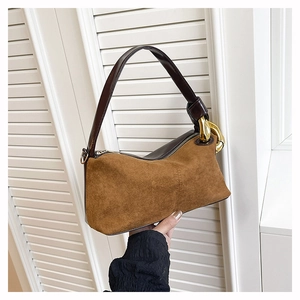 Detail of vintage brown suede handbag with golden chain buckle and leather strap