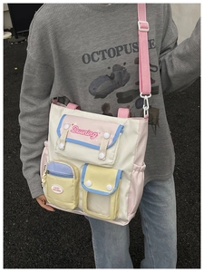Detail of multi-pocket crossbody bag with macaron color blocking and adjustable pink strap
