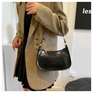 Detailed view of a black hobo underarm bag featuring retro wrinkled texture and gold hardware