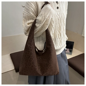 Close-up of vintage leopard print tote bag styled with an autumn knitted sweater