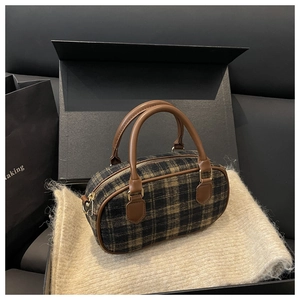 Macro shot of British style plaid bowling bag in a gift box with golden zippers