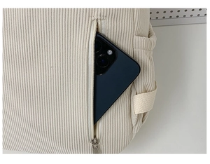 Detail der Cord-Rucksack-Seitentasche mit Smartphone als Größenreferenz im Inneren