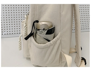 Detail der Cord-Rucksack-Seitentasche in Creme mit einem champagnerfarbenen Regenschirm