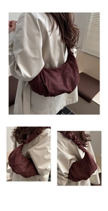 Détail du sac croissant plissé bordeaux en daim doux avec bandoulière assortie élégante