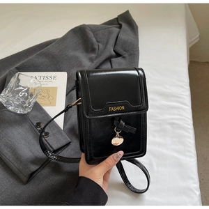 Détail d'un mini sac bandoulière noir brillant avec lettrage Fashion doré sur tissu
