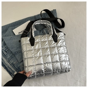 Détail du sac cabas argenté matelassé avec motifs carrés et bandoulière noire