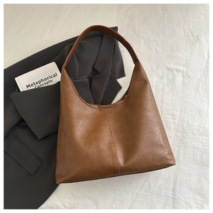 Gros plan sur un grand sac cabas vintage en cuir marron avec coutures verticales