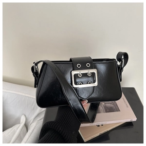 Detail of black glossy underarm bag featuring a large silver square buckle and strap