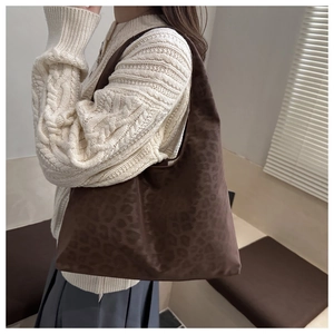 Brown leopard print tote bag in textured fabric showing side view on shoulder