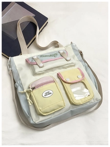 Detail of multi-pocket crossbody school bag with pastel color blocks and adjustable straps