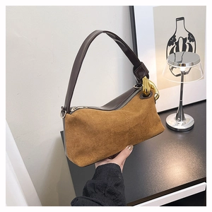Detail of vintage brown suede handbag featuring golden chain strap and leather handle