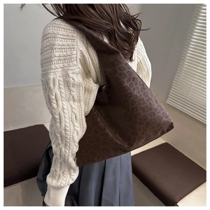 Brown leopard print tote bag styled on model back showing its large capacity and texture