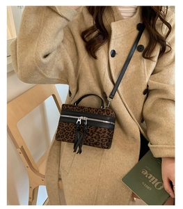 Détail du sac boîte léopard avec doubles glands et bandoulière réglable noire