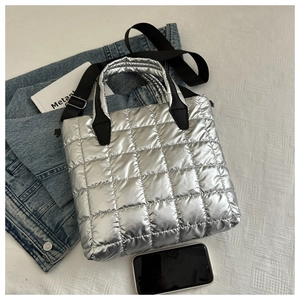 Détail du cabas matelassé argenté avec bandoulière réglable et accessoire de téléphone