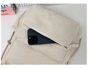 Detail der vorderen Cord-Rucksacktasche, die den Platz für ein Smartphone zeigt