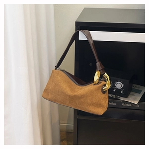 Detail of vintage brown suede shoulder bag featuring premium gold metal buckle hardware