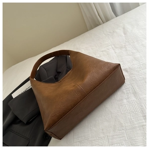 Gros plan détaillé du sac hobo en cuir texturé marron avec coutures vintage épurées