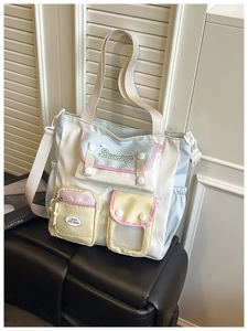 Detail of multi-pocket nylon tote bag with colorful contrast panels and adjustable strap