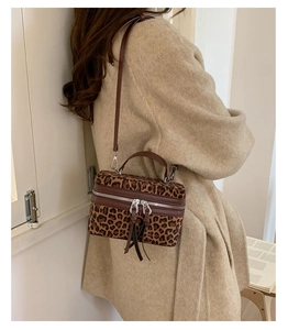 Détail du mini sac léopard vintage avec poignée en cuir et fermetures éclair argentées