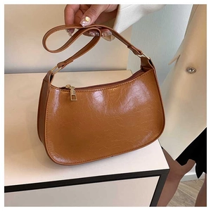 Detail of caramel brown hobo bag with vintage pleated texture and metal zipper