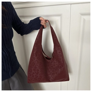 Close-up of burgundy leopard print tote bag with soft leather texture and large handle
