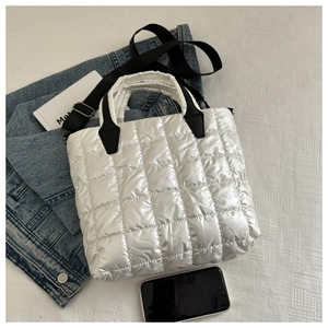 Gros plan du sac fourre-tout rembourré blanc avec des sangles noires sur texture